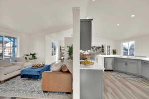 Living room featuring lofted ceiling, light wood-style flooring, and recessed lighting