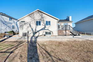 Back of property featuring central air condition unit, fence, and stairs