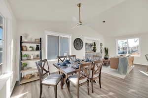 Dining area with lofted ceiling, light wood-style flooring, and ceiling fan