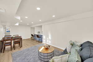 Basement Living room with light wood finished floors, recessed lighting