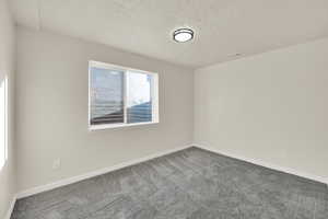 Bedroom with new carpet, a textured ceiling,  and large closet