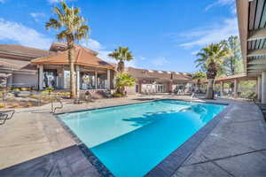 Community pool with a patio area and fence