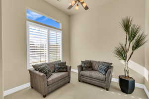 Sitting room featuring ceiling fan, carpet, and baseboards