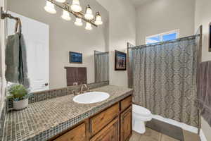 Full bathroom featuring tile patterned flooring, a shower with curtain, vanity, and toilet