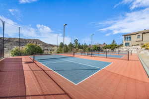 View of tennis court featuring community basketball court, fence, and a mountain view