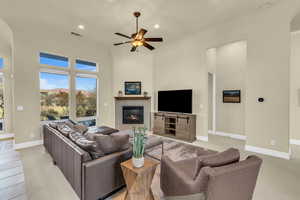 Living room with ceiling fan, recessed lighting, a fireplace, visible vents, and baseboards