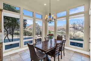 Dining area with a chandelier, light tile patterned floors, a mountain view, recessed lighting, and baseboards