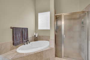 Full bath featuring a stall shower and a garden tub