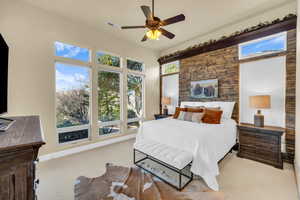 Carpeted bedroom with baseboards, visible vents, and a ceiling fan