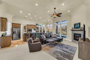 Living area with a high ceiling, a tiled fireplace, and a healthy amount of sunlight