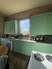 Kitchen featuring white range with electric stovetop, dishwasher, brick wall, stainless steel microwave, and a sink