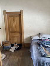 Bedroom with dark wood finished floors and baseboards