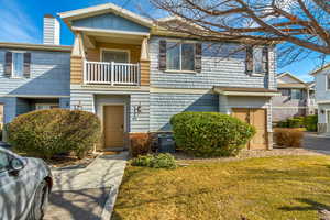 Townhome / multi-family property featuring a front yard, cooling unit, and a balcony