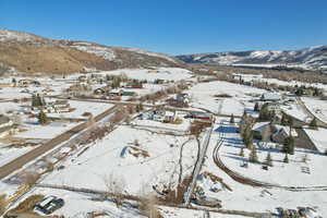 Snowy aerial view featuring a residential view and a mountain view