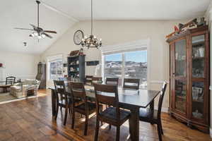 Dining room with dark wood-style floors, a wealth of natural light, and lofted ceiling