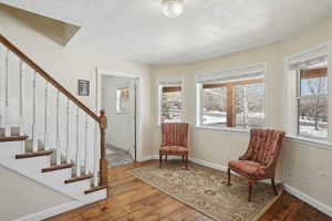 Living area with plenty of natural light, baseboards, and hardwood / wood-style flooring