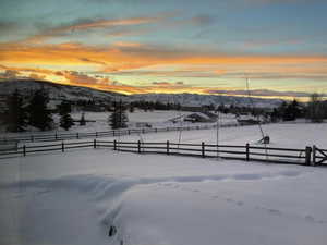 Snowy yard featuring fence and a mountain view