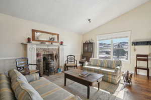 Living area with vaulted ceiling, a textured ceiling, and hardwood / wood-style flooring