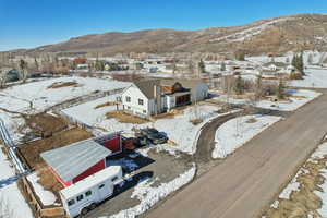 Snowy aerial view with a mountain view and a residential view