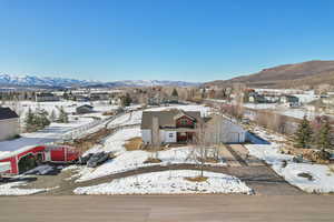 Snowy aerial view featuring a residential view and a mountain view