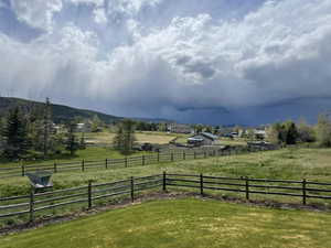 View of yard featuring a rural view, fence, and a mountain view