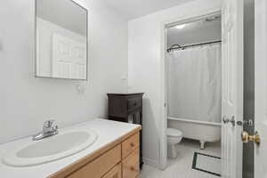 Full bathroom featuring a tub to relax in, toilet, a shower with shower curtain, vanity, and tile patterned flooring