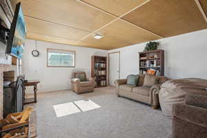 Carpeted living area with a fireplace and baseboards