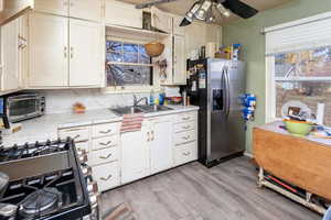 Kitchen with light countertops, stainless steel fridge, light wood-style flooring, and a toaster