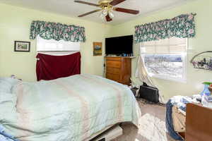 Carpeted bedroom featuring ceiling fan and a textured ceiling