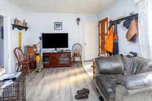 Living room featuring a textured ceiling and wood finished floors