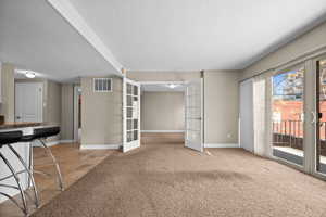 Interior space featuring carpet floors, french doors, visible vents, and baseboards