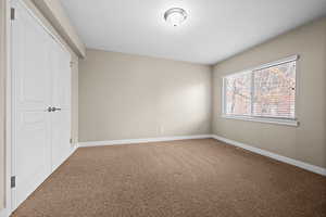 Unfurnished bedroom with a closet, carpet flooring, and baseboards