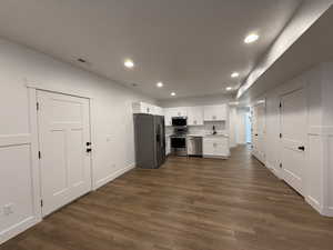 Kitchen with visible vents, dark wood-type flooring, stainless steel appliances, light countertops, and a sink