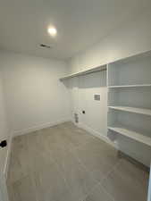 Washroom featuring hookup for an electric dryer, laundry area, washer hookup, visible vents, and baseboards