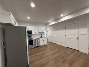 Kitchen with stainless steel appliances, dark wood-style flooring, a sink, and recessed lighting