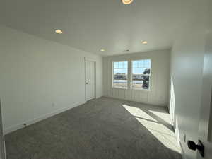 Carpeted empty room with baseboards, a textured ceiling, and recessed lighting