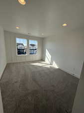 Empty room featuring a textured ceiling, carpet flooring, and recessed lighting