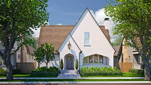 Tudor home with a chimney, fence, and stucco siding