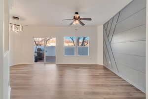 Empty room featuring ceiling fan, light wood-style flooring, and baseboards