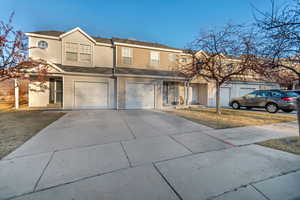 Multi unit property featuring driveway and an attached garage