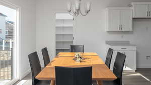 Dining room with dark wood finished floors, baseboards, and an inviting chandelier