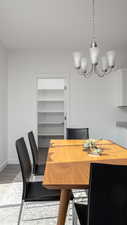 Dining room with light wood-style floors, a notable chandelier, and baseboards