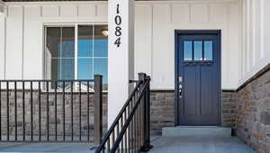 Property entrance featuring stone siding and board and batten siding