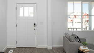 Foyer entrance featuring baseboards, visible vents, and wood finished floors