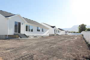 Rear view of property featuring entry steps, fence, and a mountain view