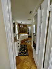 Bathroom with ornamental molding, visible vents, vanity, and an inviting chandelier