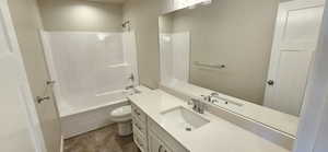 Full bath featuring vanity, washtub / shower combination, and toilet