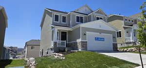 Craftsman-style home with a garage, a front yard, stone siding, concrete driveway, and a residential view