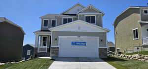 Craftsman house featuring a garage, a front lawn, stone siding, and concrete driveway