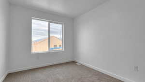 Carpeted empty room with visible vents and baseboards